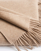 close-up texture detail of beige cashmere fringe throw blanket