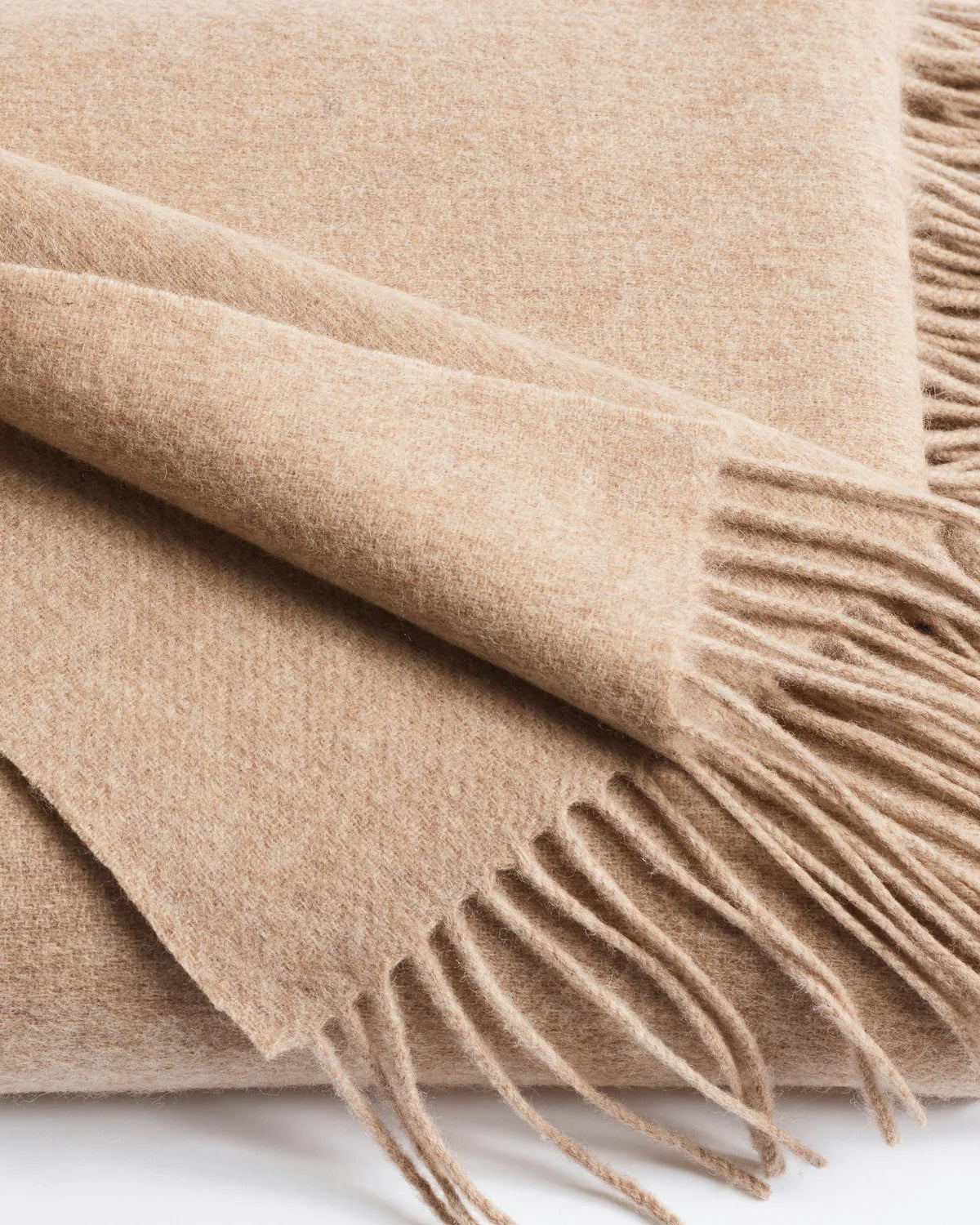 close-up texture detail of beige cashmere fringe throw blanket